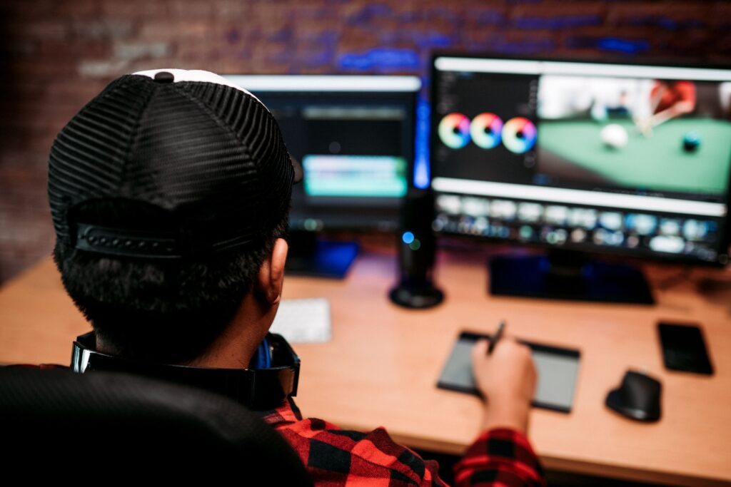 Blogger sitting in his armchair in front of the computer, editing his videos in his home